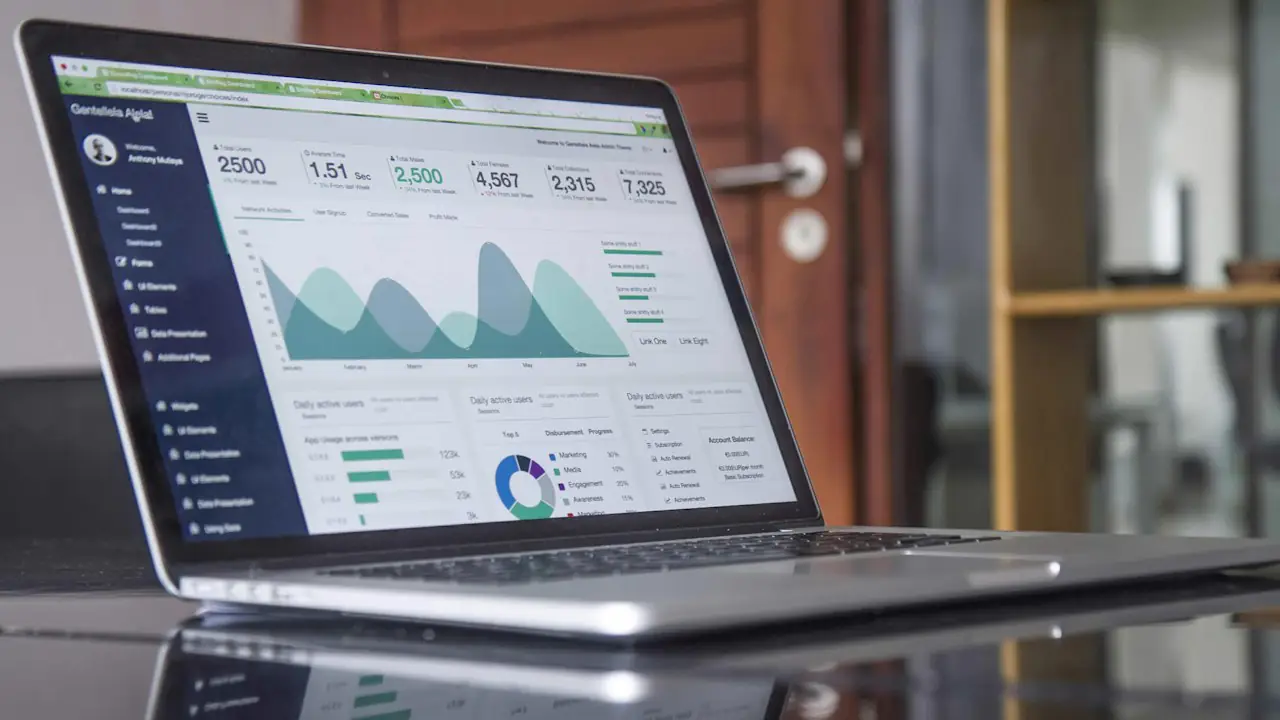 A laptop showing an accounting dashboard with charts and totals