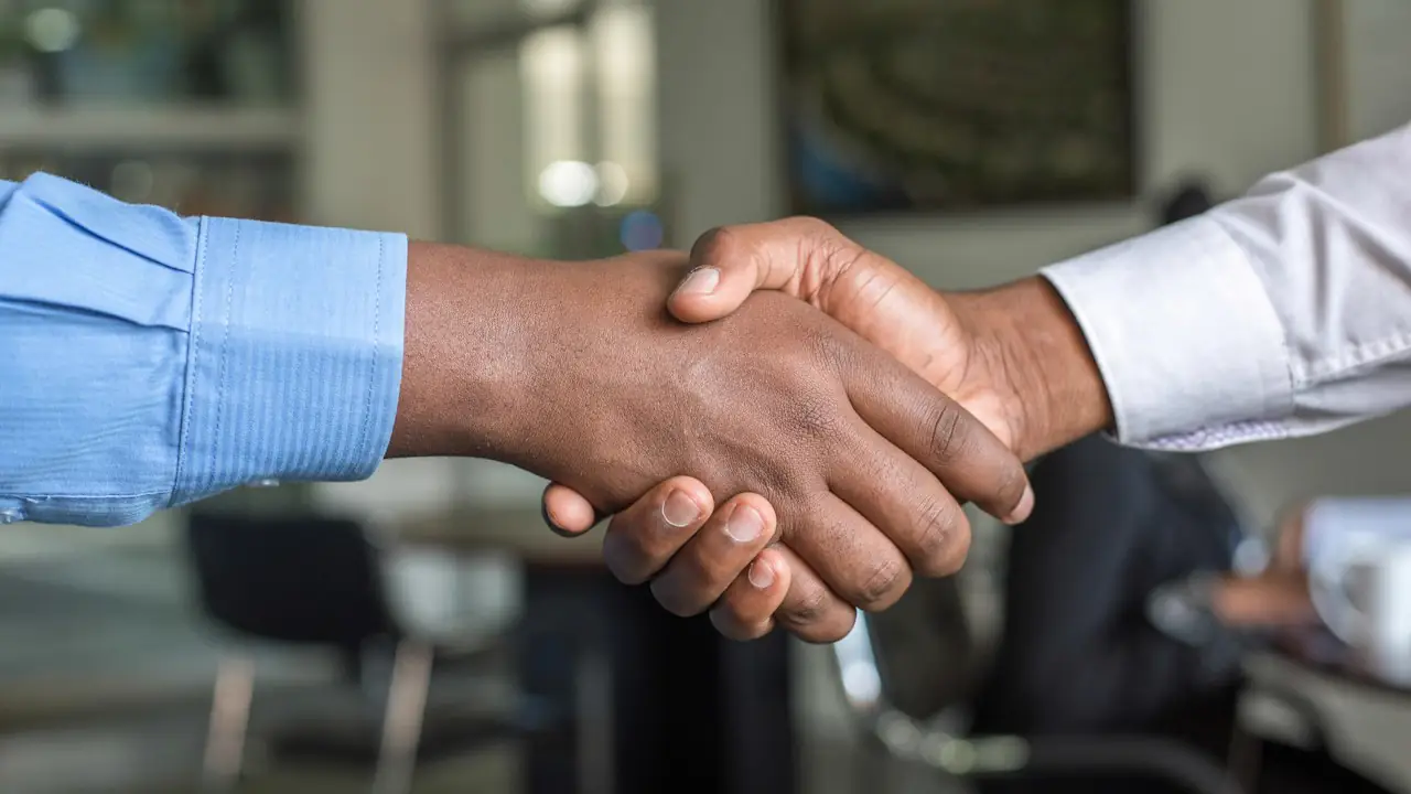 Two business people shaking hands in an office