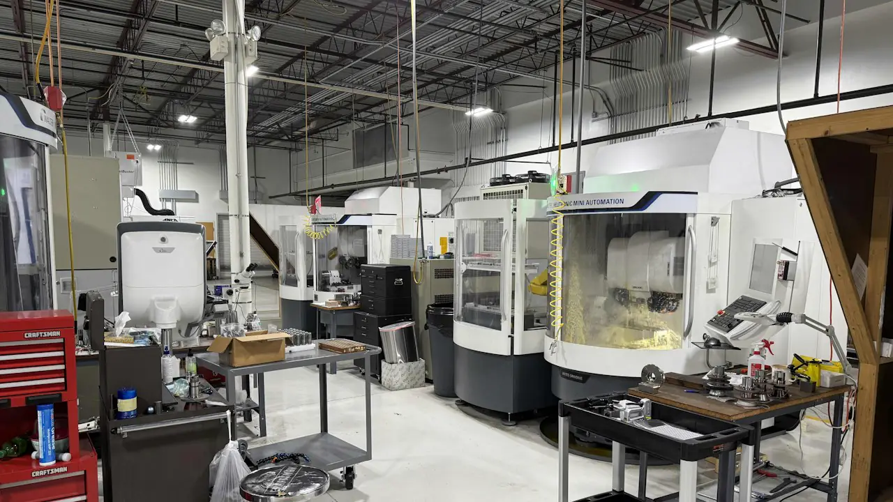 A bright machine shop with a row of computer controlled milling machines