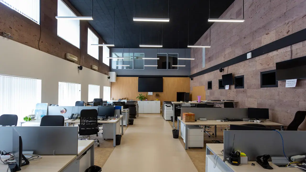 A long open plan office with rows of desks, chairs and computers