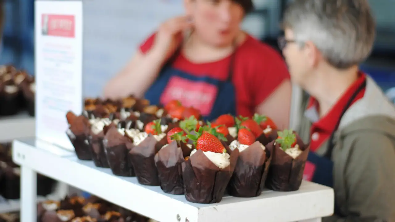 Volunteers at a table of cupcakes at a fundraiser