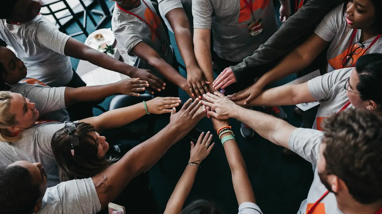 Volunteers joining hands in a circle