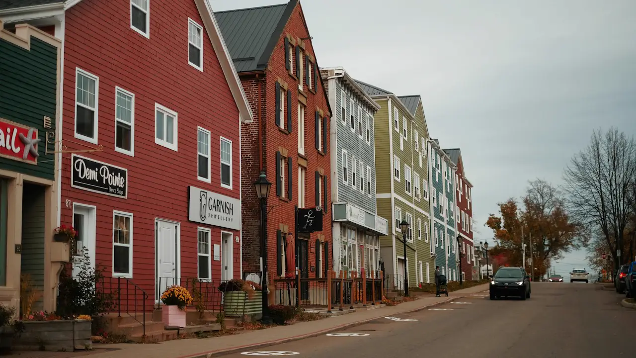 A row of brightly painted heritage buildings along a Charlottetown street in autumn