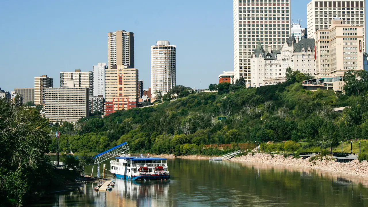 Downtown Edmonton above the river valley, with a riverboat on the water