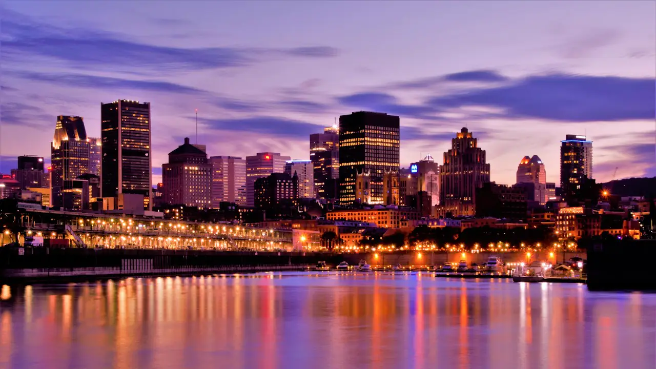 The Montreal skyline lit up at dusk and reflected in the water
