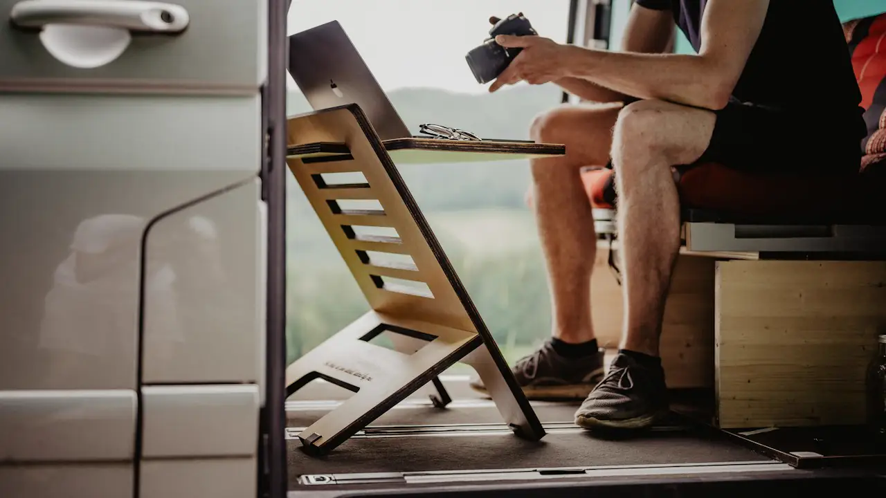 A person working at a fold down desk inside a van