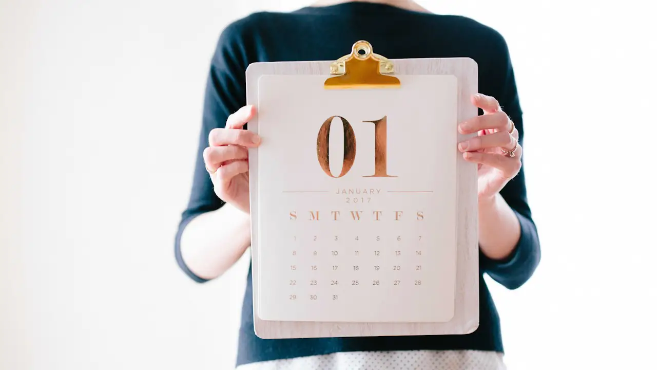 A person holding a calendar page for the first of the month