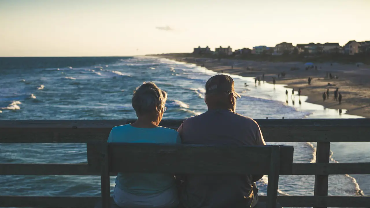 A couple sitting on a bench overlooking the sea
