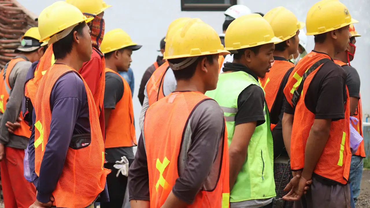 A work crew in hard hats and safety vests