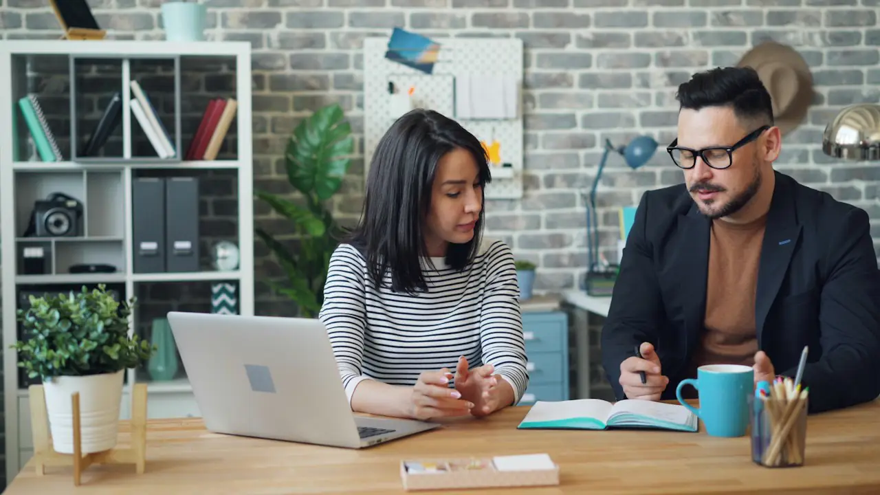 Two people in a calm discussion across a desk