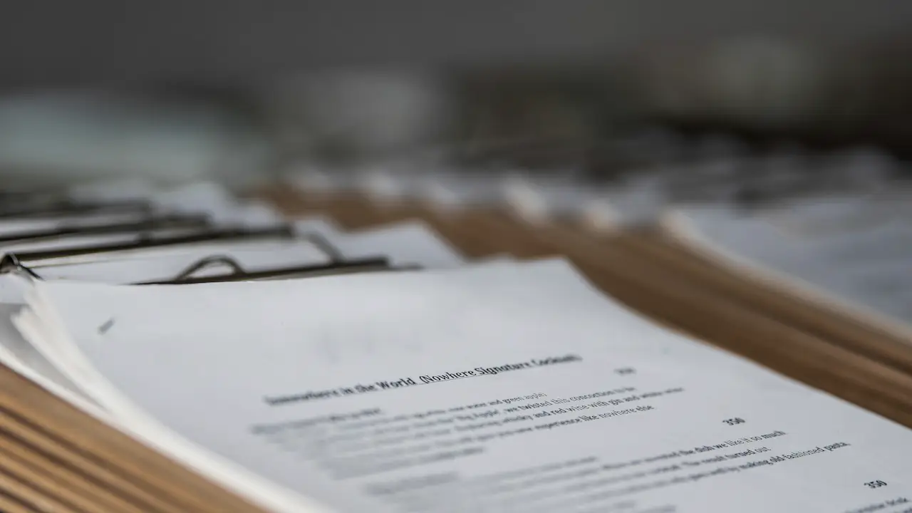 A deep stack of printed documents and reports