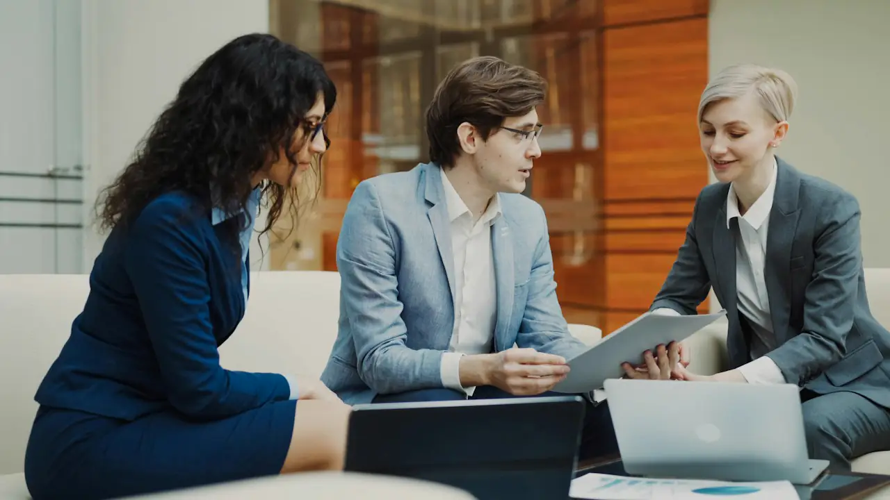 Three colleagues reviewing figures on a tablet together