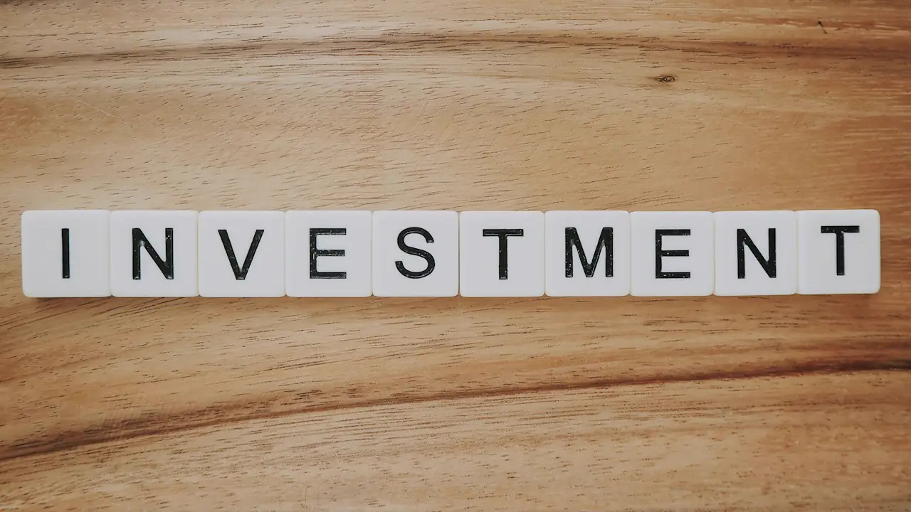 Letter tiles spelling investment on a wooden surface