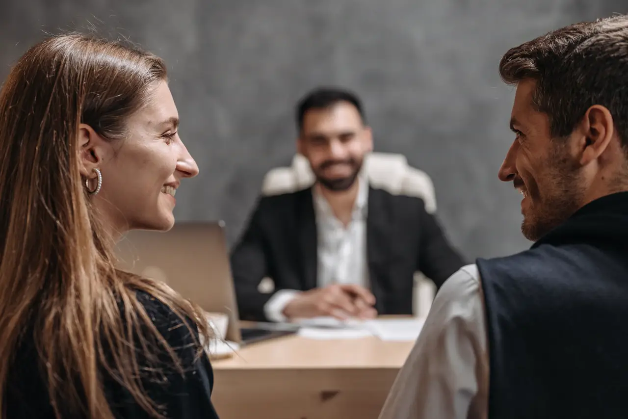 Smiling professionals sit together through a friendly client meeting in an office