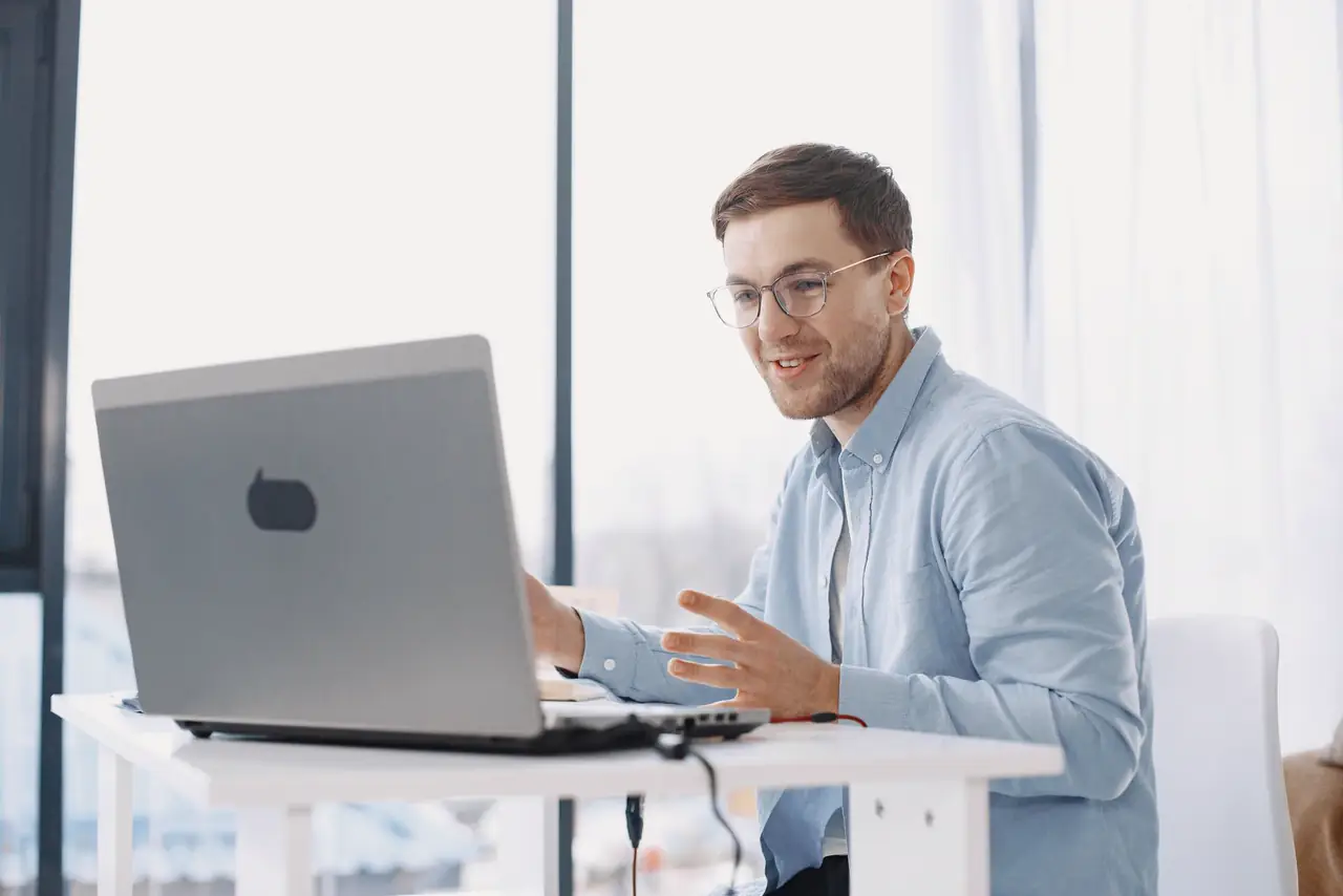 Consultant works on a laptop at a desk in a bright home office