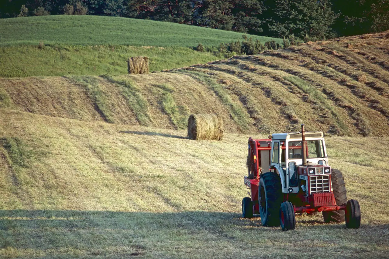 Tractor works on a farm in Brant, Ontario, Canada at dusk
