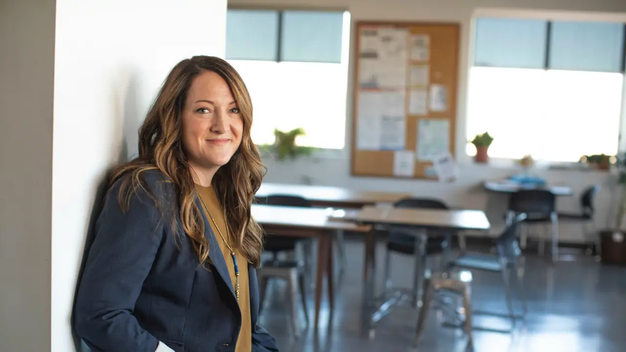 A smiling business owner in a blazer in a bright office