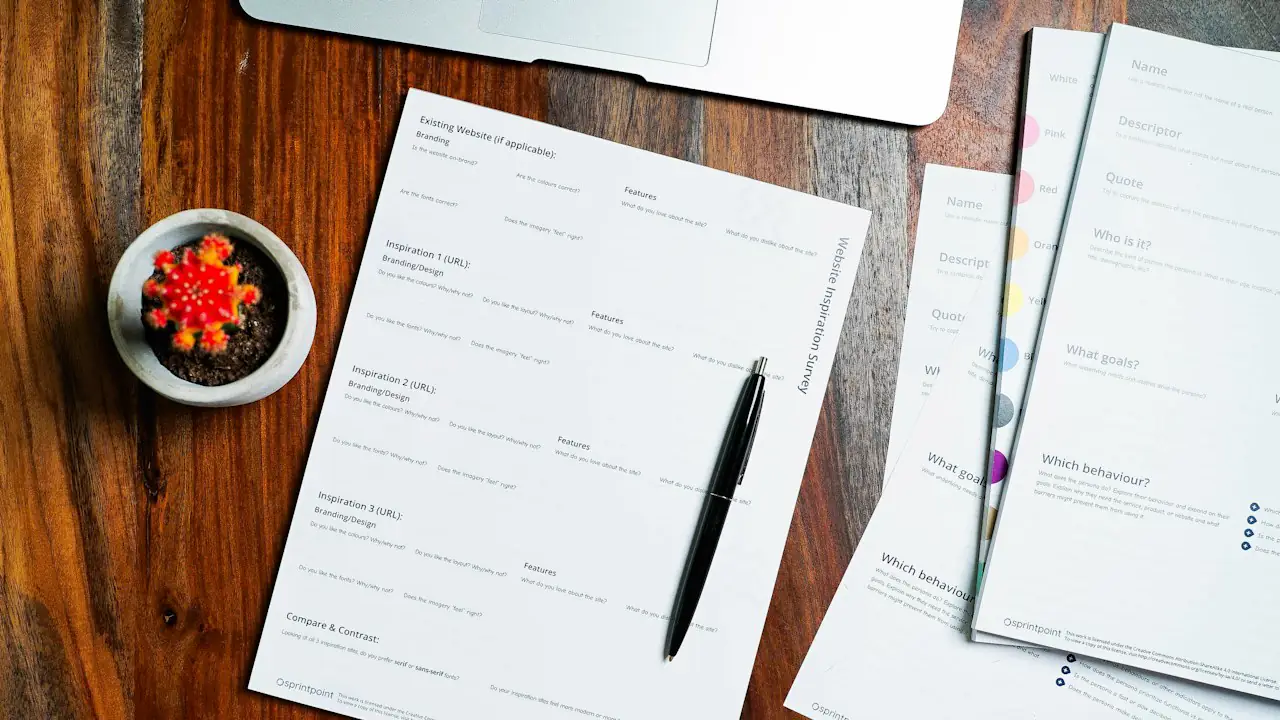 Forms and a pen laid out on a wooden desk
