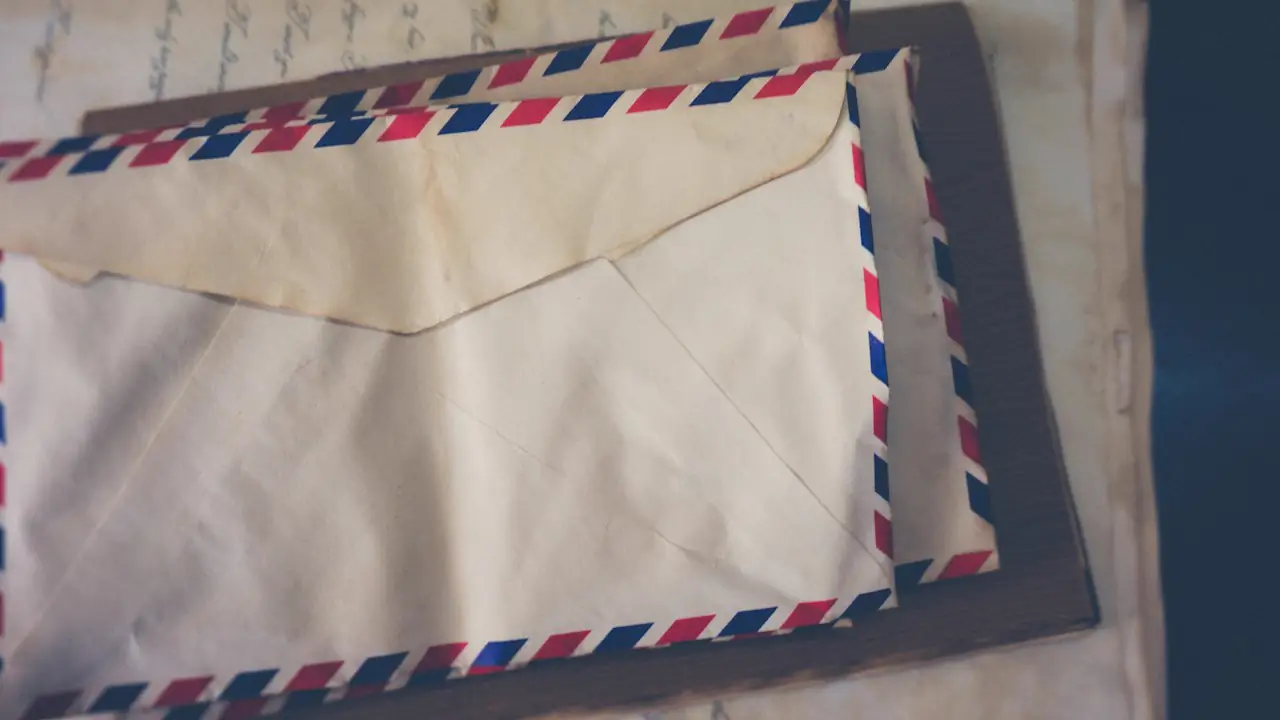 A stack of old airmail envelopes with striped borders