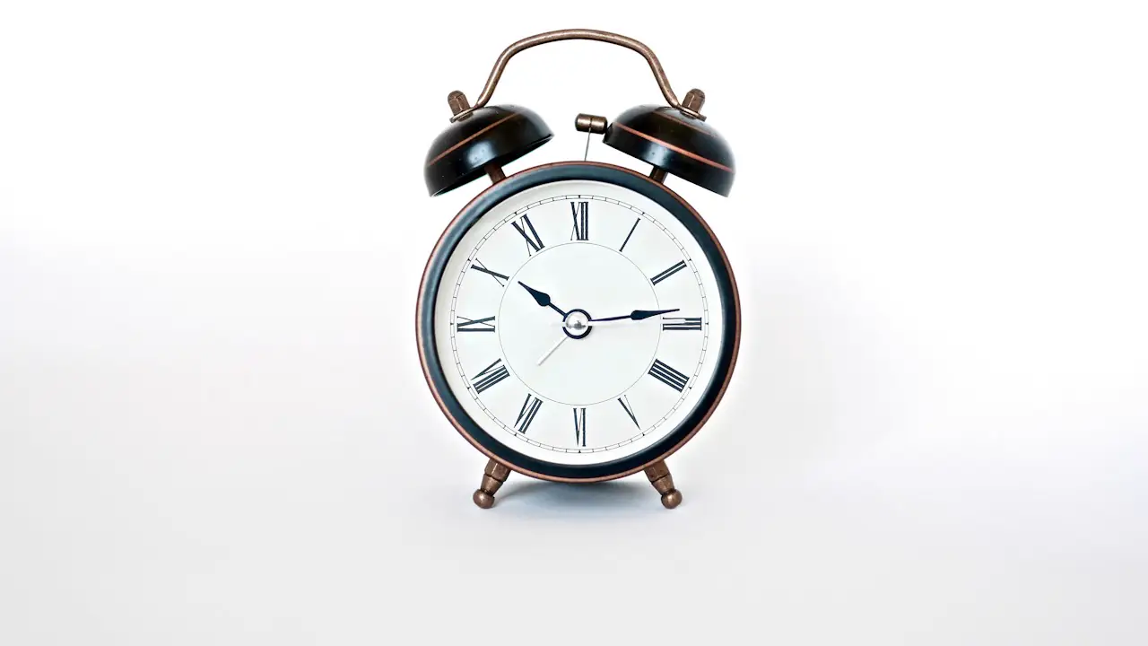 A classic alarm clock on a white background