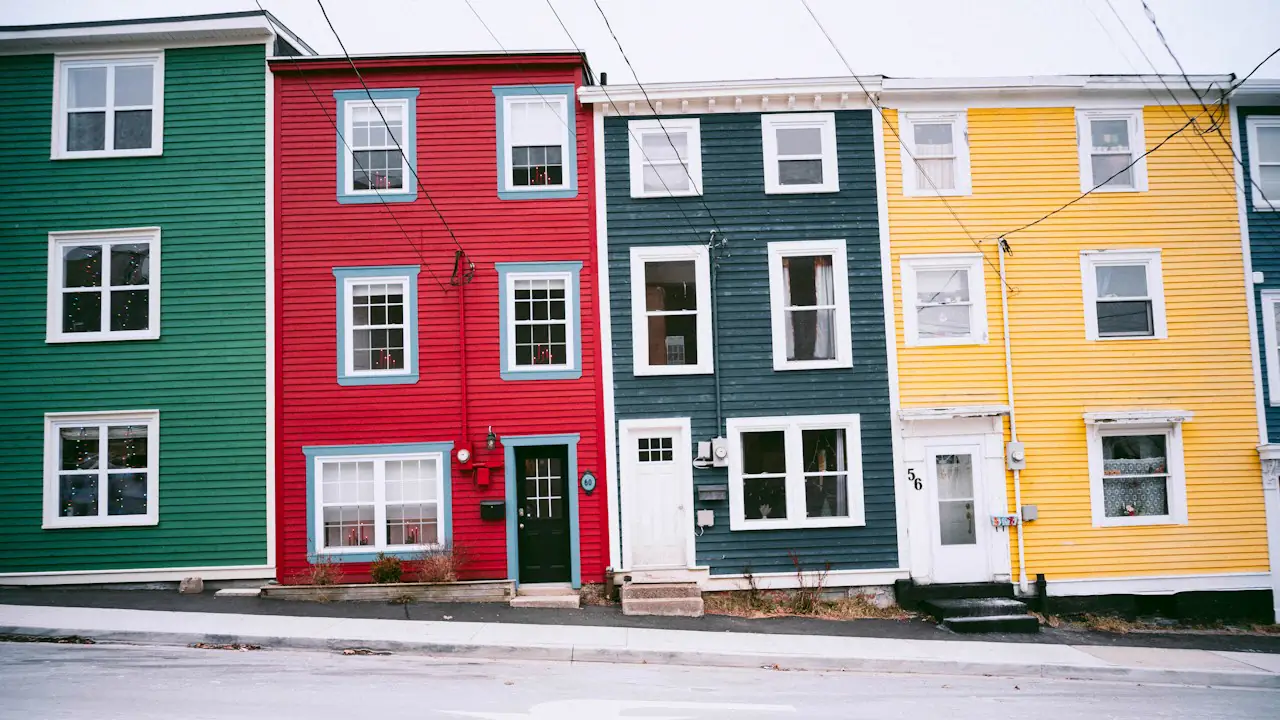 A row of brightly painted houses in green, red, navy and yellow in St. John's