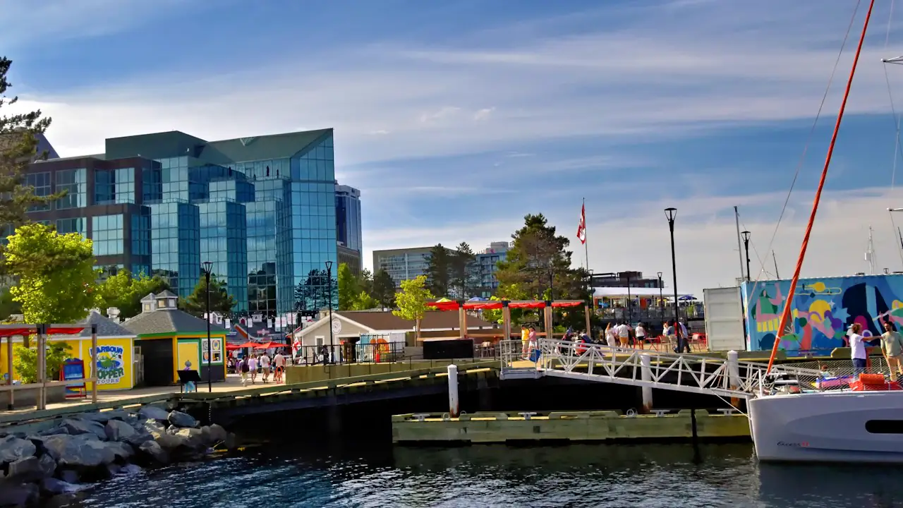 The Halifax waterfront on a sunny day, with shops, boats and people on the boardwalk