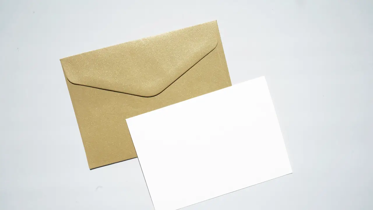 A kraft paper envelope beside a blank white card on a pale background