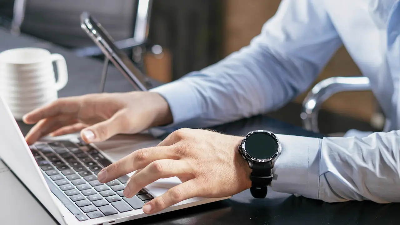 A person in a dress shirt typing on a laptop