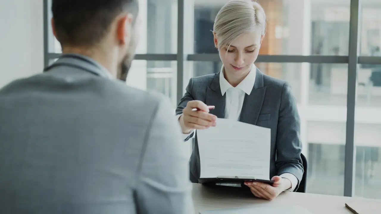 Two professionals reviewing a document across a desk
