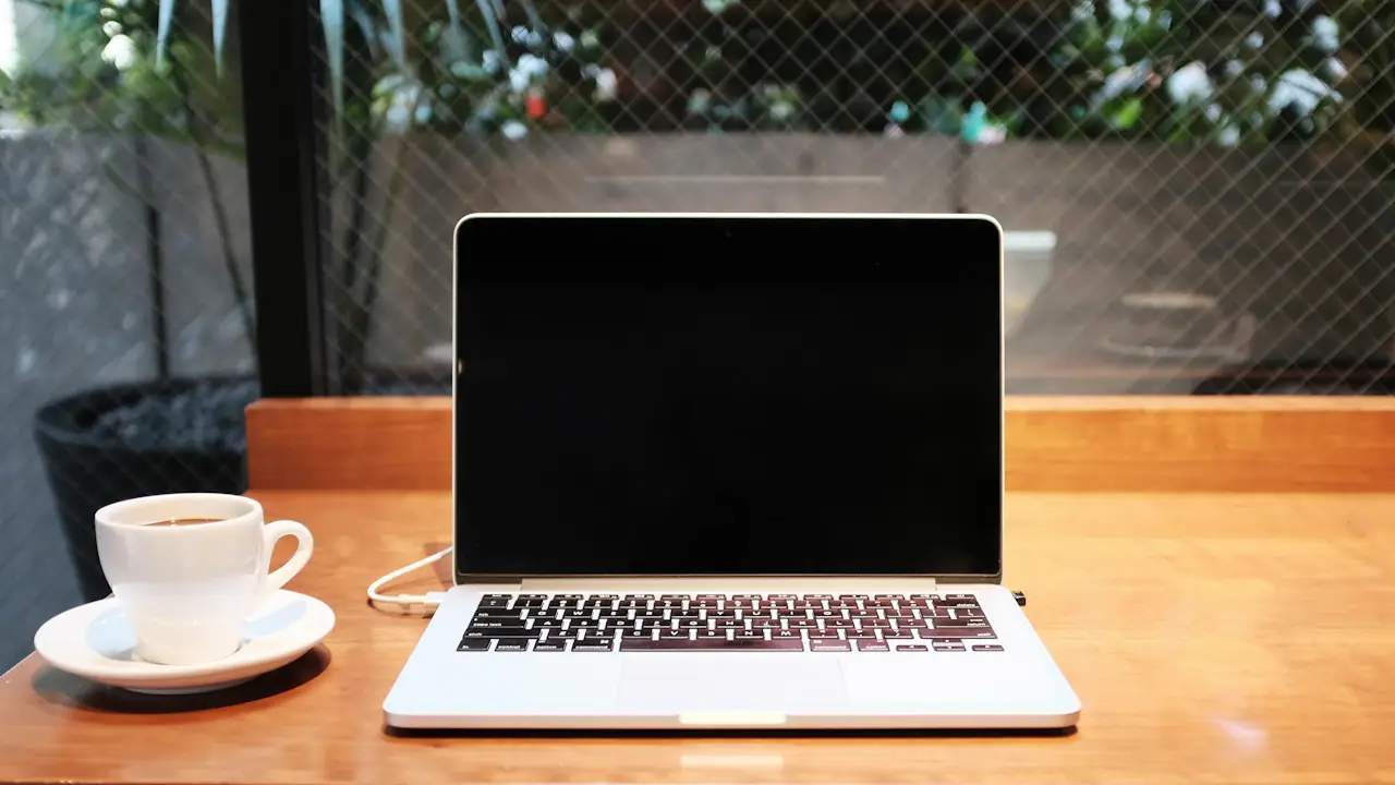 A laptop and a cup of coffee on a cafe table