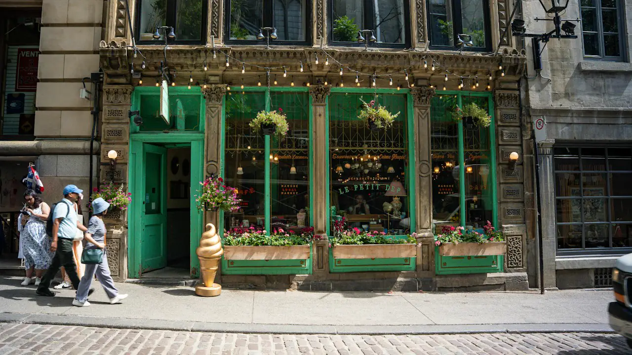 A green fronted café with flower boxes on a cobblestone street in Old Montréal