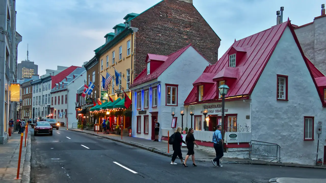 Red roofed stone houses and shops along a street in Old Québec