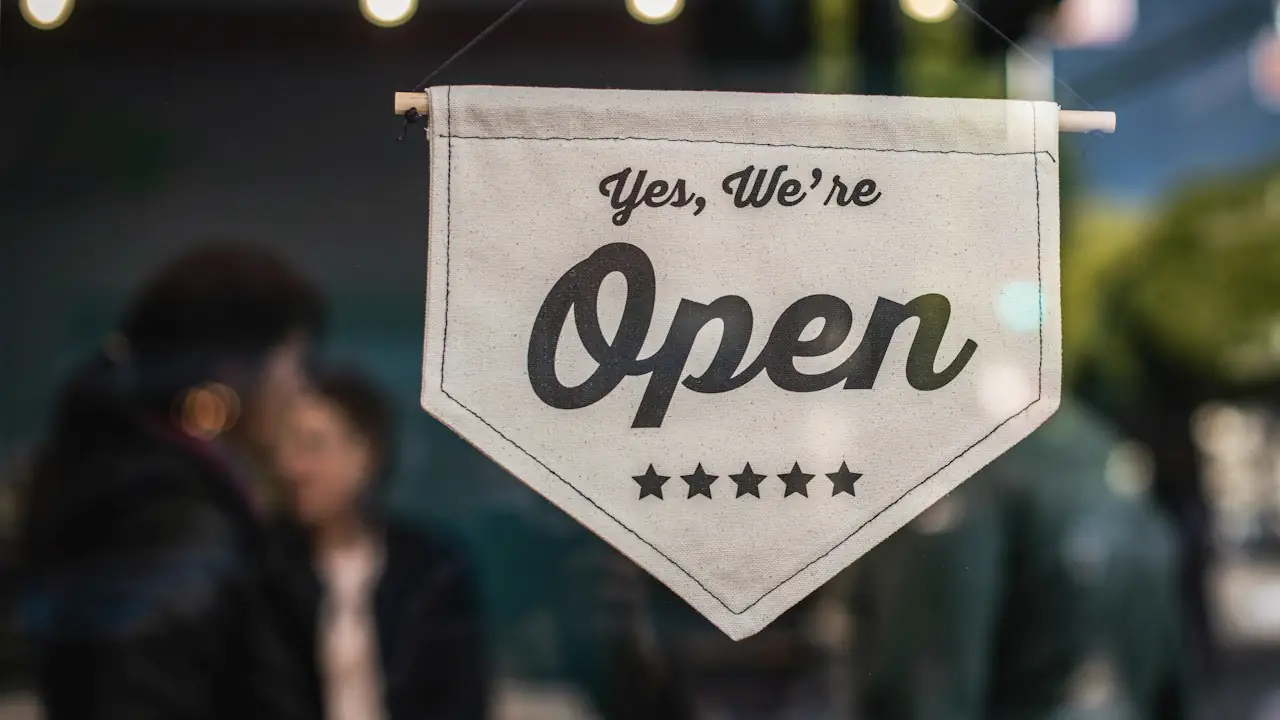 A pennant sign reading Yes, We're Open hanging in a shop