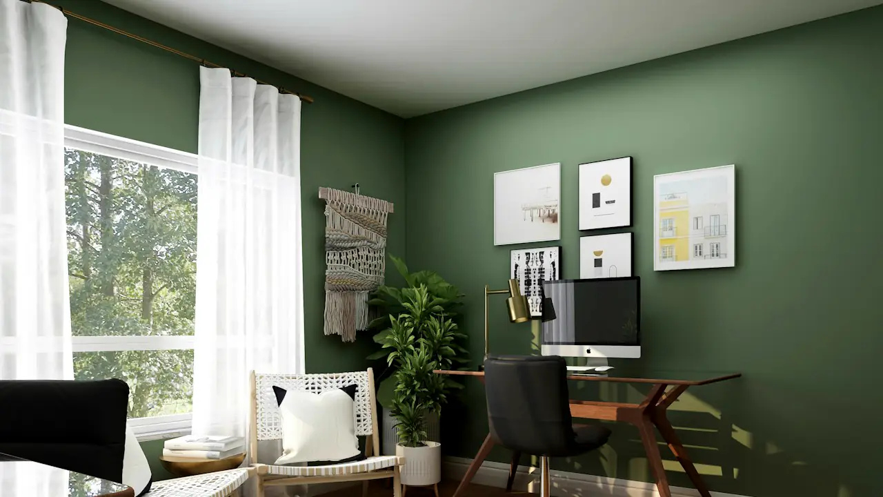 A tidy home office with green walls, a desk, a computer and a window onto trees