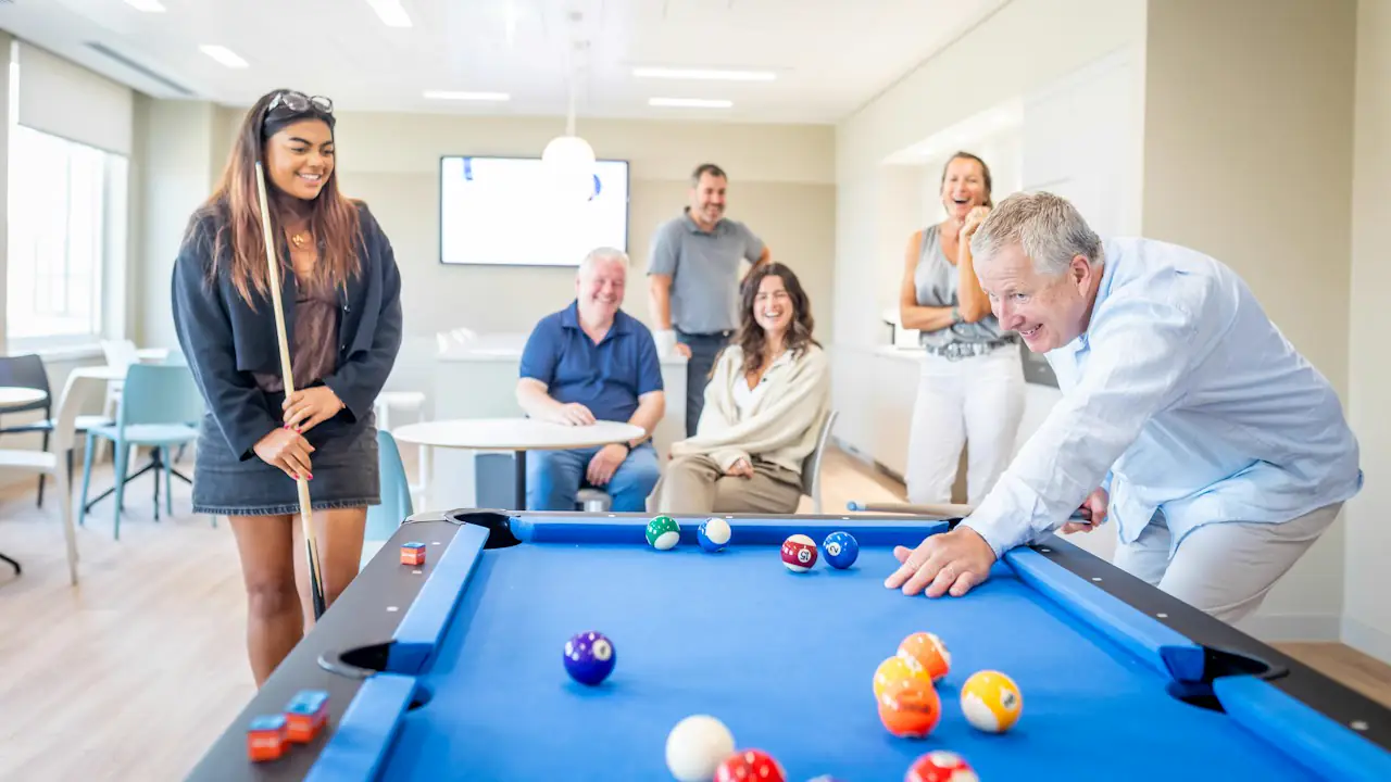 Colleagues playing pool in a bright staff lounge