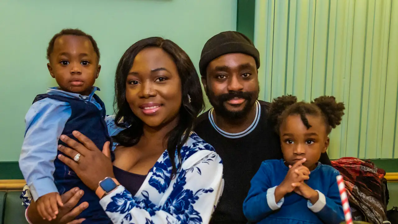 A smiling mother and father at home with their young son and daughter