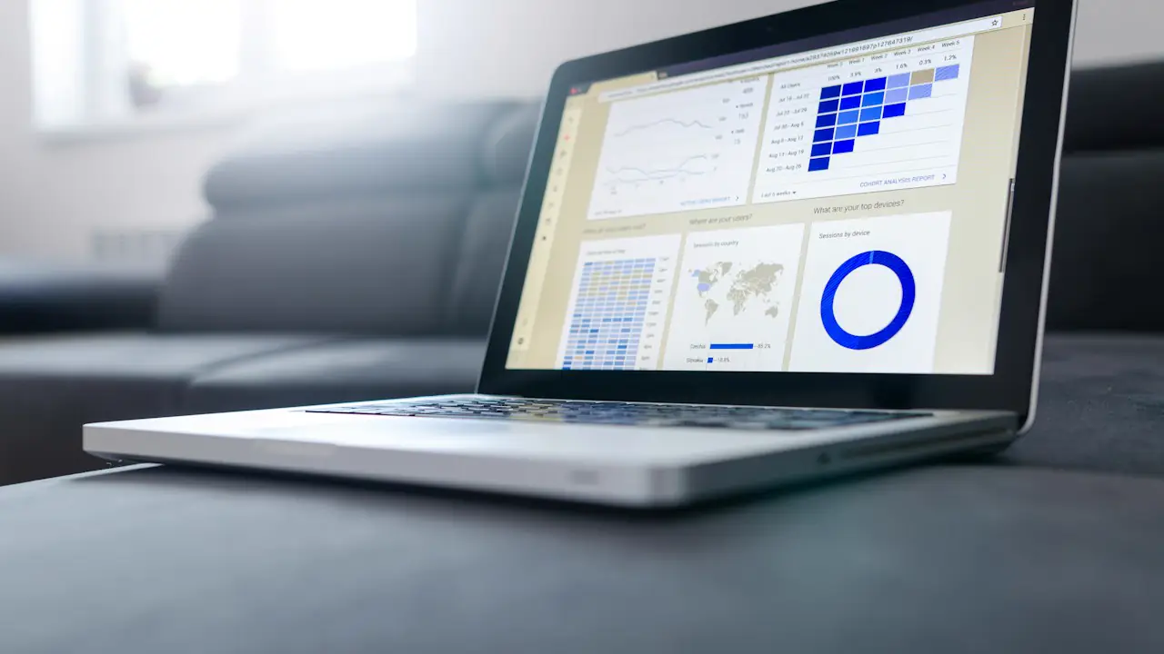A laptop on a sofa showing a financial dashboard